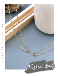 Macro shot of gold necklace featuring a minimalist round bezel-set zircon pendant