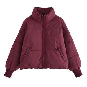 Macro detail of wine red puffer jacket featuring side zip pockets and stand collar