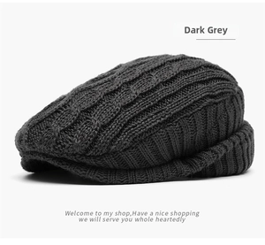 Detail of dark grey cable knit wool beret showing premium texture and weave patterns