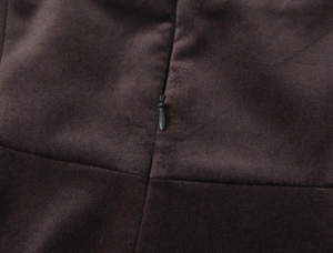 Détail d'une fermeture éclair invisible sur le tissu velours marron d'une robe