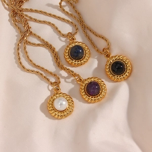 Détail de colliers en or 18 carats avec pendentifs en agate sur soie rose élégante