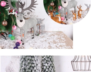 Detailed view of artificial reindeer family ornaments in a snowy Christmas tree setting