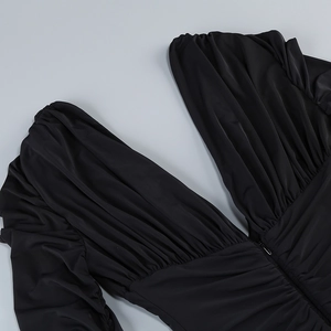 Dettaglio dello scollo a V nero con design a pieghe e consistenza del tessuto elastico