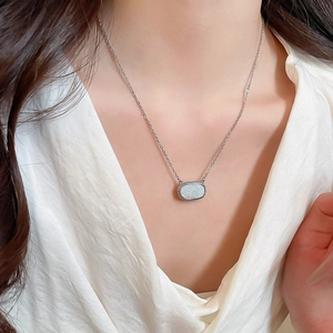 Detail of silver chain with oval drusy pendant and beaded metal trim on model