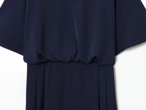 Gros plan détaillé sur les plis à la taille et l'épaule tombante d'une robe midi marine