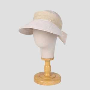 Dettaglio cappello parasole bicolore in paglia con fiocco decorativo su supporto