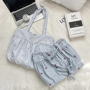 Detail of blue striped tote bag and shorts with red bow embroidery on white bedding