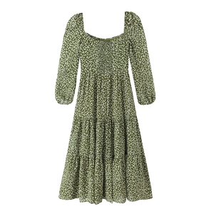 Robe longue verte à pois à col carré et jupe à plusieurs niveaux sur fond blanc uni