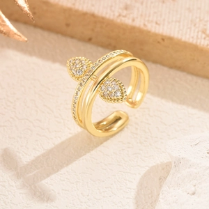 Vue rapprochée d'une bague dorée avec motifs double poire et pavé de zircone cubique