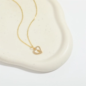 Elegant gold heart pendant necklace with micro-inlaid stones and religious icon carving