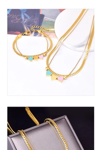 Close-up of golden double-layer heart jewelry set with blue and pink heart pendants