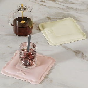 Detail of square wavy silicone coasters with 3D X-pattern on marble surface