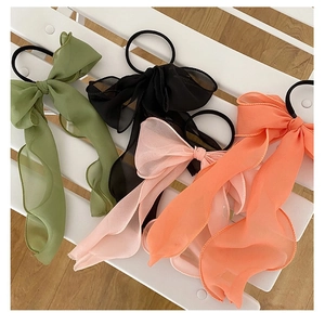 Chiffon bow hair scrunchies in green, black, pink and coral set on white texture