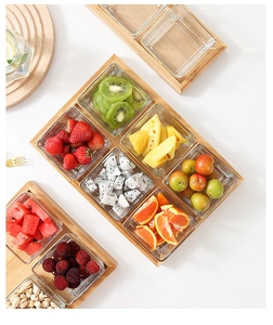 Detail of square glass serving bowls with bamboo trays for fruits and snacks