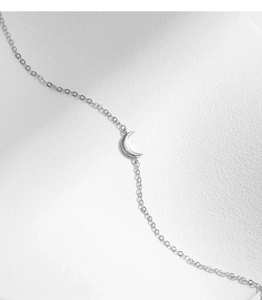 Detailed view of 925 sterling silver crescent moon bracelet on white texture