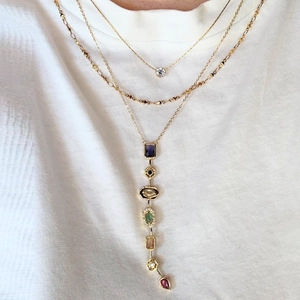 Macro view of gold-layered necklace featuring vibrant geometric gemstone pendants