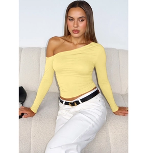 Détail du haut asymétrique jaune clair avec manches longues et tissu à texture côtelée fine