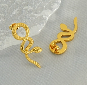 Detailed close-up of gold snake studs showing intricate scale texture and butterfly backings