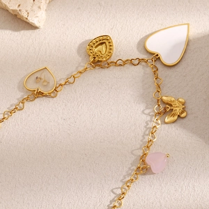Detail of 18K gold-plated bracelet with mixed heart charms, crystal, and dried flower charms