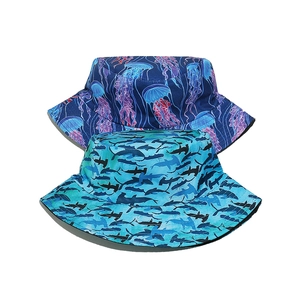 Detail of summer bucket hats featuring deep blue jellyfish and shark silhouette patterns