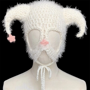 Detailed view of white crochet devil horn hat with pink star accents on feather yarn