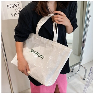 Detail of large transparent PVC tote bag with Skillfully lettering and white canvas base
