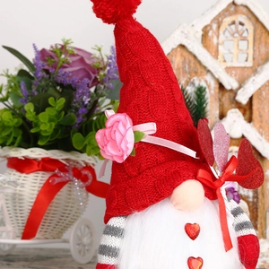 Détail d'un gnome de Noël avec bonnet rouge en tricot, fleur et barbe à bouton en cœur