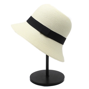 Japanese style cream straw bucket hat with black ribbon trim on metal display stand