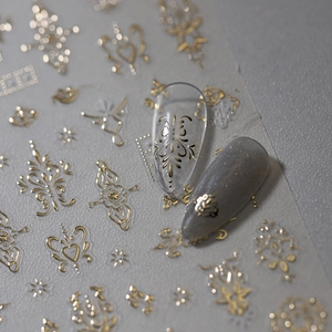 Baroque style gold foil nail stickers with vintage patterns on grey and clear nails