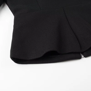 Detailed view of the bottom hem and metal zipper of the black wool-like waist coat