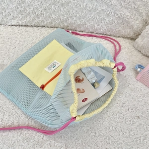 Détail d'un sac à dos en maille colorée avec poche jaune zippée et cordon à perles