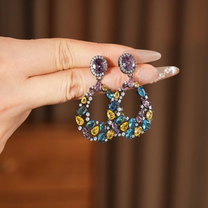 Dettaglio di orecchini vintage con zirconi multicolore e finitura in metallo scuro