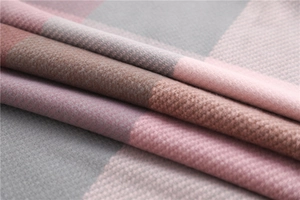 Close-up of soft plaid scarf fabric showing texture in pink, brown and grey tones