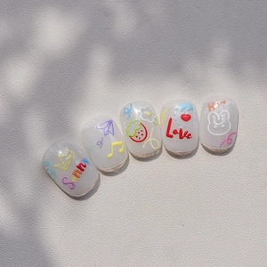 Macro detail of cute 3D embossed nail stickers featuring colorful rainbows and icons