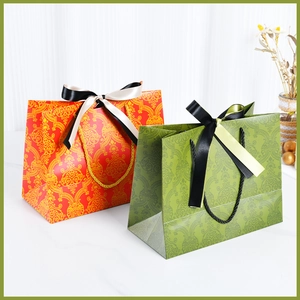 Elegant vintage floral gift bags in red and green with luxury satin ribbon bows