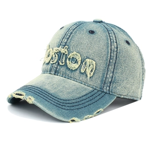 Detailaufnahme der Jeans-Baseballkappe in Hellblau mit Boston-Stickerei und Fransendetails