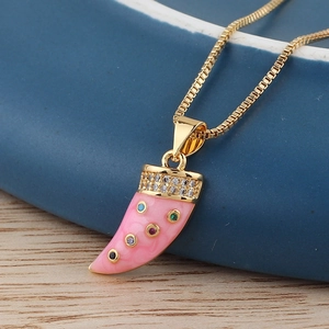 Detailed macro view of pink enamel horn pendant with colorful gems on gold chain