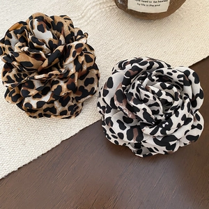 Détail de pinces à cheveux fleurs en tissu motif léopard coloris marron et gris