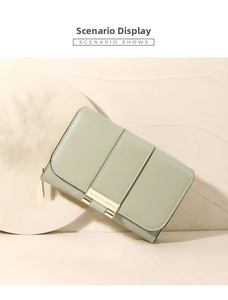 Close-up of sage green leather wallet with gold hardware and classic metal logo detail