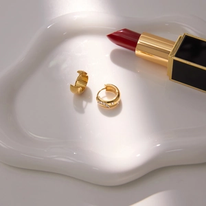 Orecchini a cerchio classici placcati in oro con cristalli bianchi su vassoio in ceramica