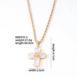 Macro detail of gold cross pendant with rectangular zircons and 60cm rope chain