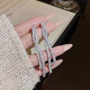 Macro detail of silver long tassel earrings featuring twisted spiral design with pavé zircons