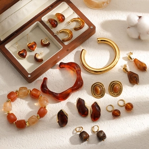 Maillard style amber resin jewelry set with golden accents and a wooden storage box