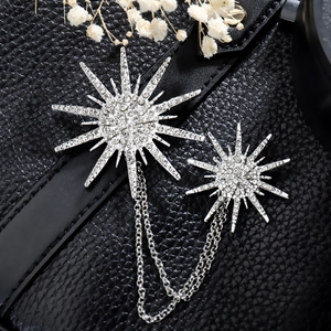 Vintage starburst chain brooch with sparkling rhinestones on elegant black leather background