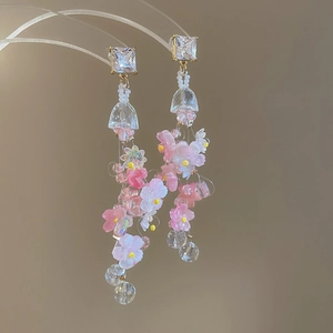 Detail of floral tassel earrings with pink flowers and transparent jellyfish beads