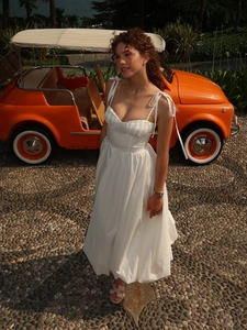 Détail d'une robe longue bustier blanche en coton avec bretelles en décor de vacances