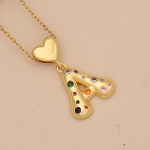 Close-up of golden heart pendant with letter A and multi-colored cubic zirconia stones