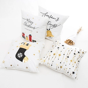 Set of four white Christmas pillow covers with gold foil letters and holiday prints
