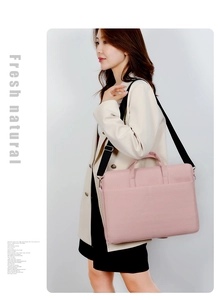 Detail einer rosa Laptop-Tasche mit schwarzem Schultergurt an einem Model getragen