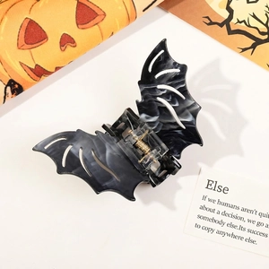 Macro detail of bat-shaped hair claw with black and white marble texture for Halloween